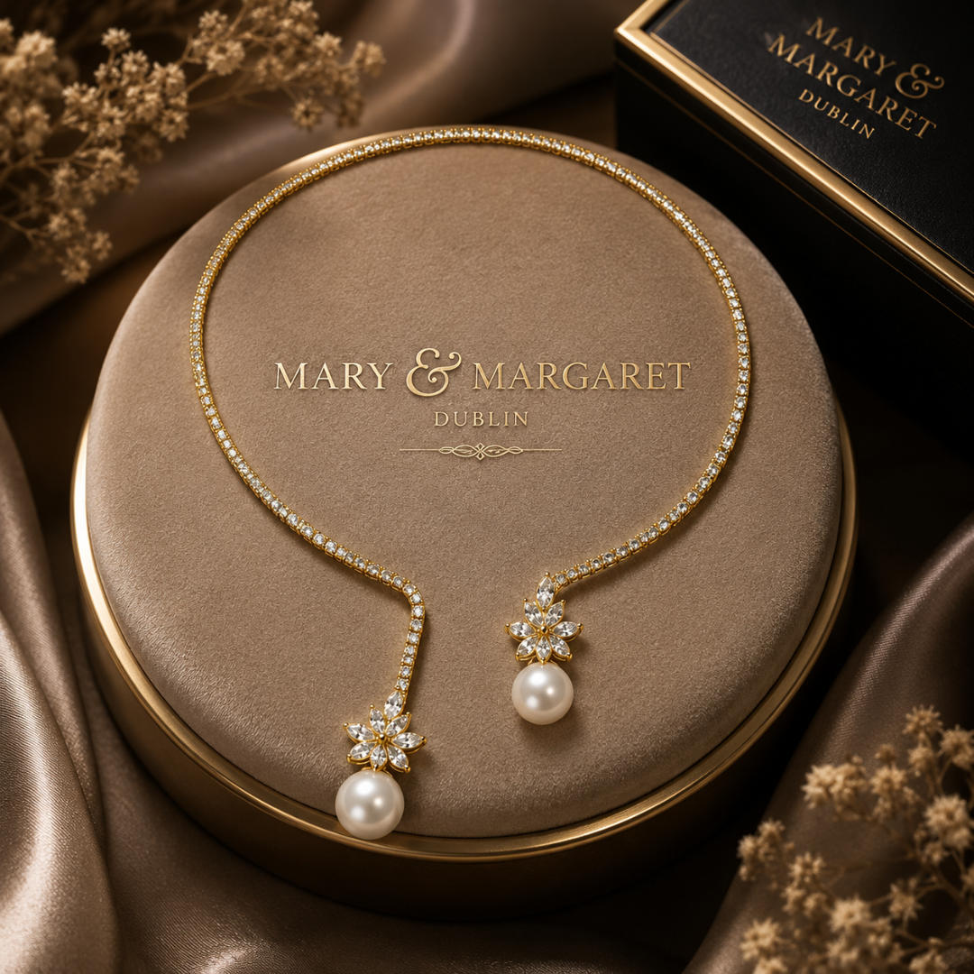 Gold-tone pearl drop necklace with two star pendants, white pearl drops, and pavé chain