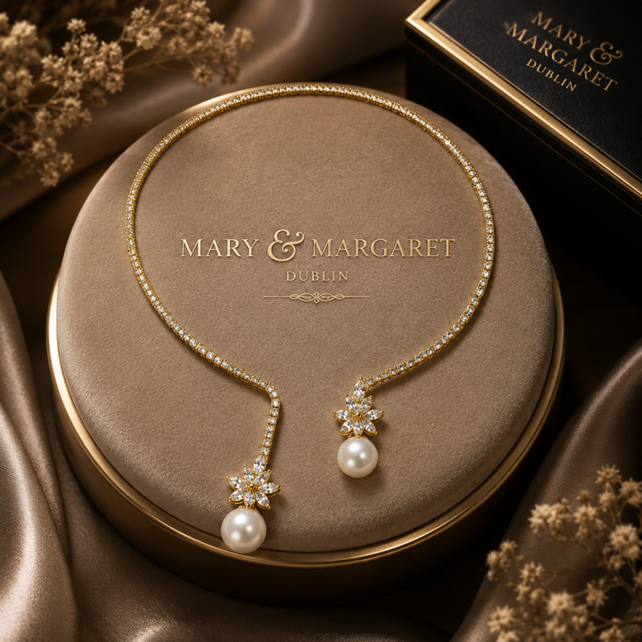 Gold-tone pearl drop necklace with two star pendants, white pearl drops, and pavé chain