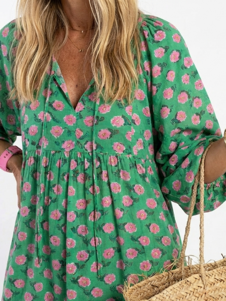 Green v-neck midi dress with pink floral pattern and gathered tiered bodice